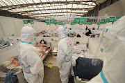 Medical workers in protective suits conduct ward rounds at Shanghai New International Exhibition Hall, which has been turned into a makeshift hospital for the coronavirus disease (Covid-19) patients, in Shanghai, China April 9, 2022.