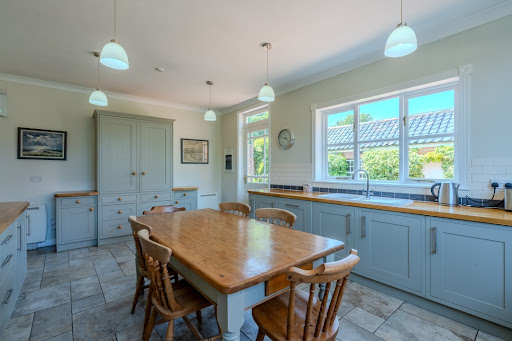 Bright kitchen with wooden table and cabinet - Property purchase in Beccles, 8 bedrooms