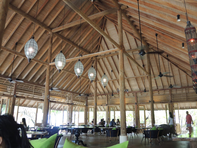 a room with tables and chairs and a ceiling fan