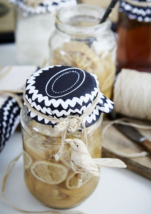 Dress up homemade food gifts with fabric covers, tied with hemp string and embellished with a tree ornament.