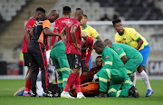 TS Galaxy's Bernard Parker is stretchered off with a broken leg after a challenge from Bongani Zungu (right), who received a red card, during the Carling Knockout Cup last 16 match at Mbombela Stadium on Sunday night. 