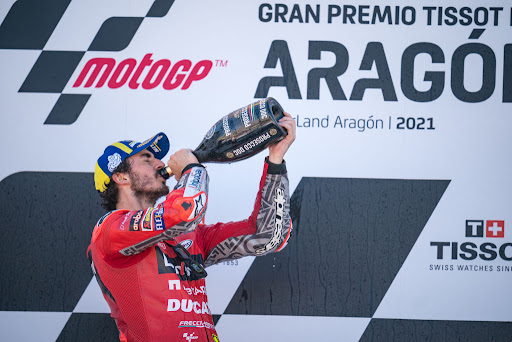 Francesco Bagnaia drinks some Prosecco after his first MotoGP win during the race of the MotoGP Gran Premio TISSOT de Aragón at Motorland Aragon Circuit on September 12, 2021 in Alcaniz, Spain.