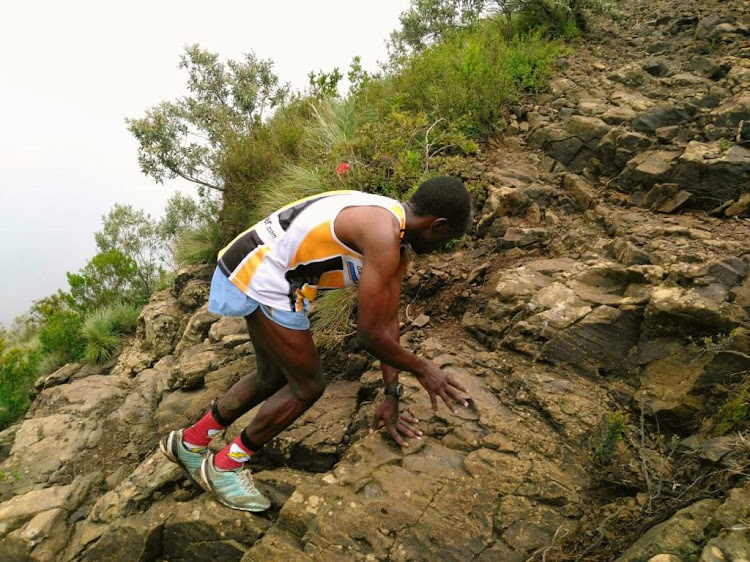 Ronald Ngige struggles to climb the rocks during a past mountain running event