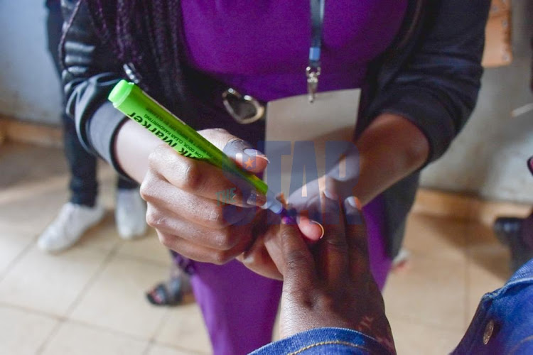 A voter being marked after casting her vote.