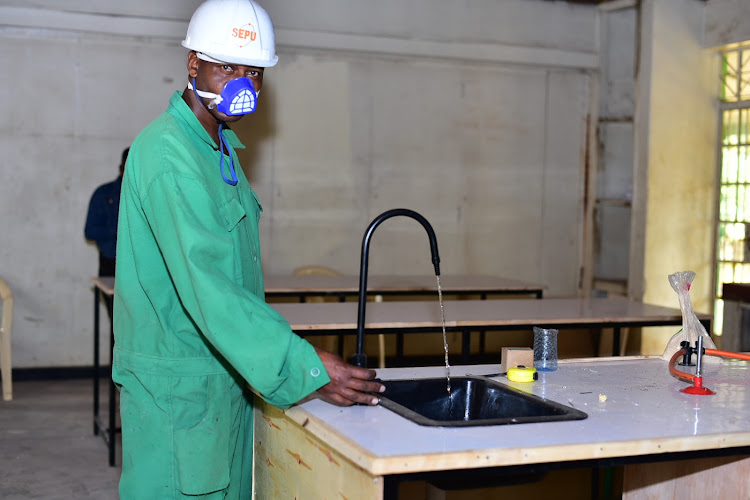 Patrick Musyoka opens a running tap during the ongoing modification of a structure at Muguga Green School Primary and Junior Secondary in Westlands on February, 27 2023