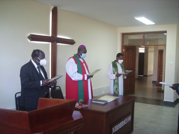 St Paul's University vice chancellor Joseph Kombo, Chairman of the university governing council Jackson ole Sapit and a member of the governing council sing at the new Joshua and Timothy Theological College on Friday.