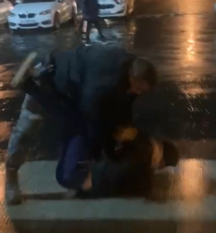 A security guard allegedly manhandling a university student.