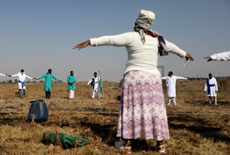 Congregants of the Inhlanhla Yokuphila Apostolic Church In Zion practise social distancing while they attend a service in a field.