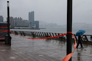 A man braves winds as Super Typhoon Saola approaches in Hong Kong, China, on September 1 2023.