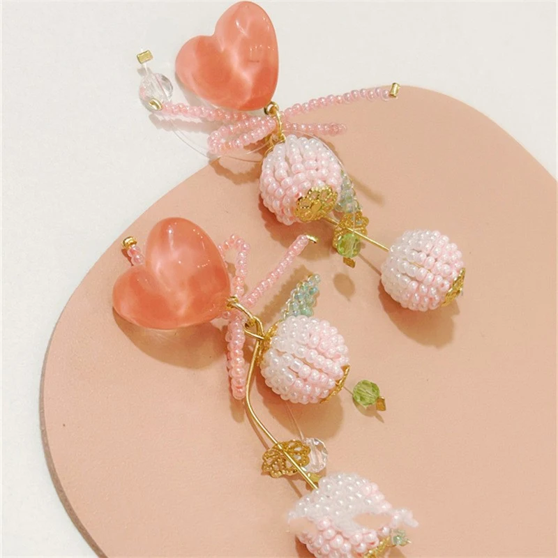 Peach roze strik oorbellen voor dames. Een schattige en romantische accessoire om je outfit op te fleuren en een vleugje liefde toe te voegen.