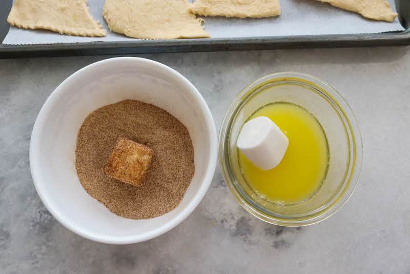 Rolling Marshmallow In Melted Butter And Cinnamon Sugar.