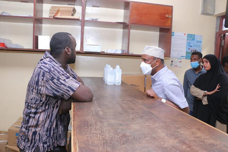 A staff engages with Garissa governor Ali Korane at the Garissa County Referral Hospital when he made an impromptu visit on Saturday morning.