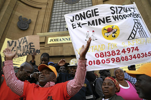 Former mineworkers with their families sings songs of victory outside the high court in Johannesburg where hearings on the silicosis settlement deal were held. / Thulani Mbele