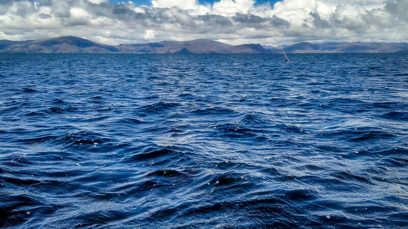 lago titicaca and andes mountains in the distance near puno peru