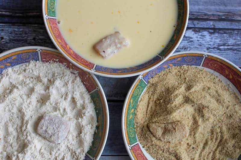 Coating The Chicken In The Flour, Eggs, And Bread Crumbs.