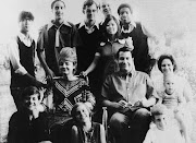 Jim Jones and his wife (left), surrounded by their adopted children. Jones is seated next to his sister-in-law (right) and her three children.