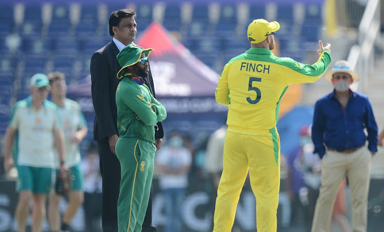 Australian captain Aaron Finch (R) toss the coin while Temba Bavuma (C) proteas captain calls it during the 2021 ICC T20 World Cup match between Australia and South Africa at Sheikh Zayed Stadium on October 23, 2021 in Abu Dhabi, United Arab Emirates.