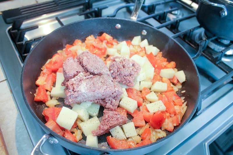 Tomatoes, Corned Beef, And Potatoes Added To The Skillet.