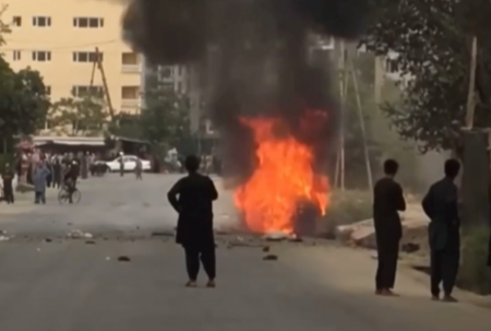 People gather around remnants of flames from cars where rockets towards Kabul's international airport were fired from but were intercepted by a missile defense system, in Kabul, Afghanistan, on August 30 2021 in this still image taken from video provided on social media. Picture: AAMAJ NEWS AGENCY via REUTERS