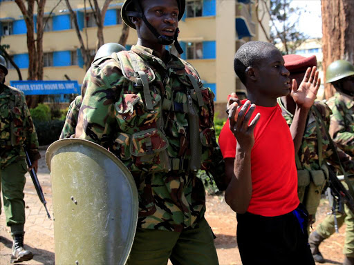 Anti-riot policemen arrest a student of University of Nairobi after protests against the detention of an opposition legislator in Nairobi on September 28, 2017