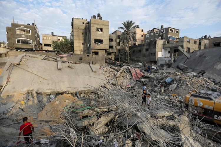 People search through buildings destroyed during Israeli air raids in the southern Gaza Strip on October 27 2023 in Khan Yunis.