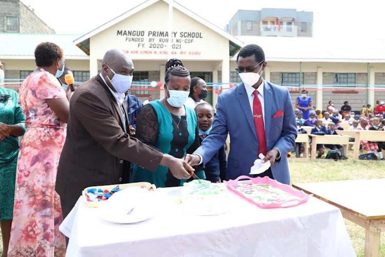 Ruiru MP Simon King'ara, parents and learners cut a cake to mark the official opening of Manguo Primary School in Githurai 45 on Monday.