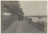Man en een vrouw in klederdracht op een dijk bij Volendam