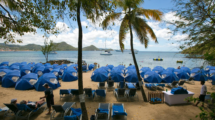 Windstar umbrellas and cots set up for a beach barbecue on Pigeon Island, St. Lucia. 