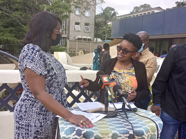 Run for Office Kenya founder Wilkister Aduma and Tribeless Youth Executive Director Shiko Kihika share a light moment during a press conference in Nairobi on December 9, 2021