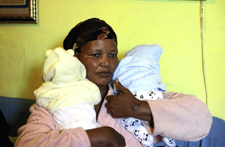 Nombuso Mbilini with the twin babies of her son Mzimasi, 27, who was shot dead at a spaza shop in Khayelitsha last month. He was among 13 victims who died from gunshot wounds that weekend.