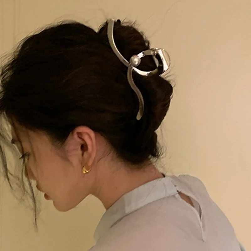 Oversized Pearl Wave Grip haarclip voor dames. Houd je haar stijlvol en comfortabel vast, ideaal voor een elegante en verfijnde look.