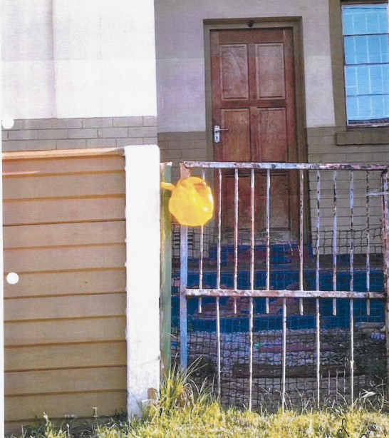 A house with a yellow “flag” put up to indicate the residents need food assistance. Photo taken from court application by Cradle of Hope.