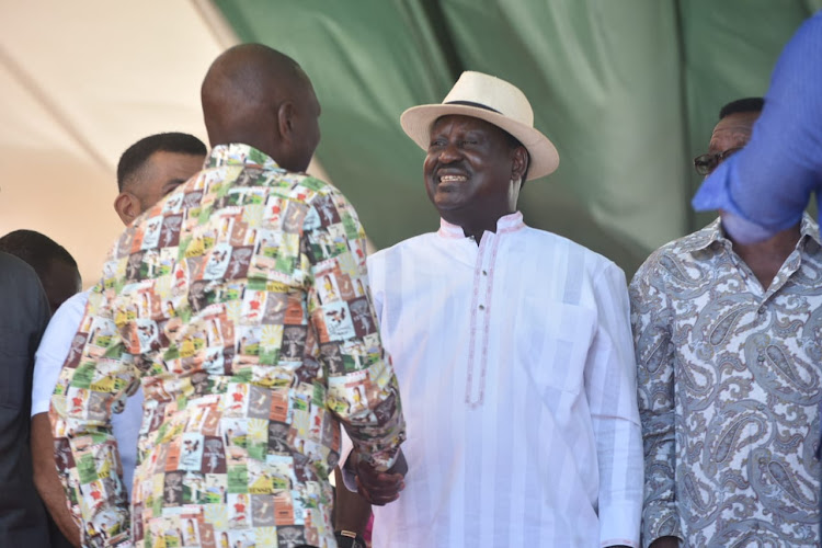 Deputy President William Ruto shakes hands with ODM leader Raila Odinga during the Mashujaa Day Celebrations in Mombasa.