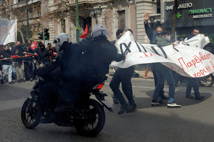 A riot police officer hits a protester as clashes take place during a demonstration following the collision of two trains, near the city of Larissa, in Athens on March 5 2023. REUTERS/ALKIS KONSTANTINIDIS