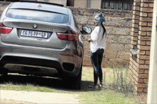 shattered: Kelly Khumalo, girlfriend of late Senzo Meyiwa, outside her Vosloorus home in Ekurhuleni next to her boyfriend's car yesterday. Meyiwa was shot in a robbery at Khumalo's home on Sunday evening PHOTO: Veli Nhlapo