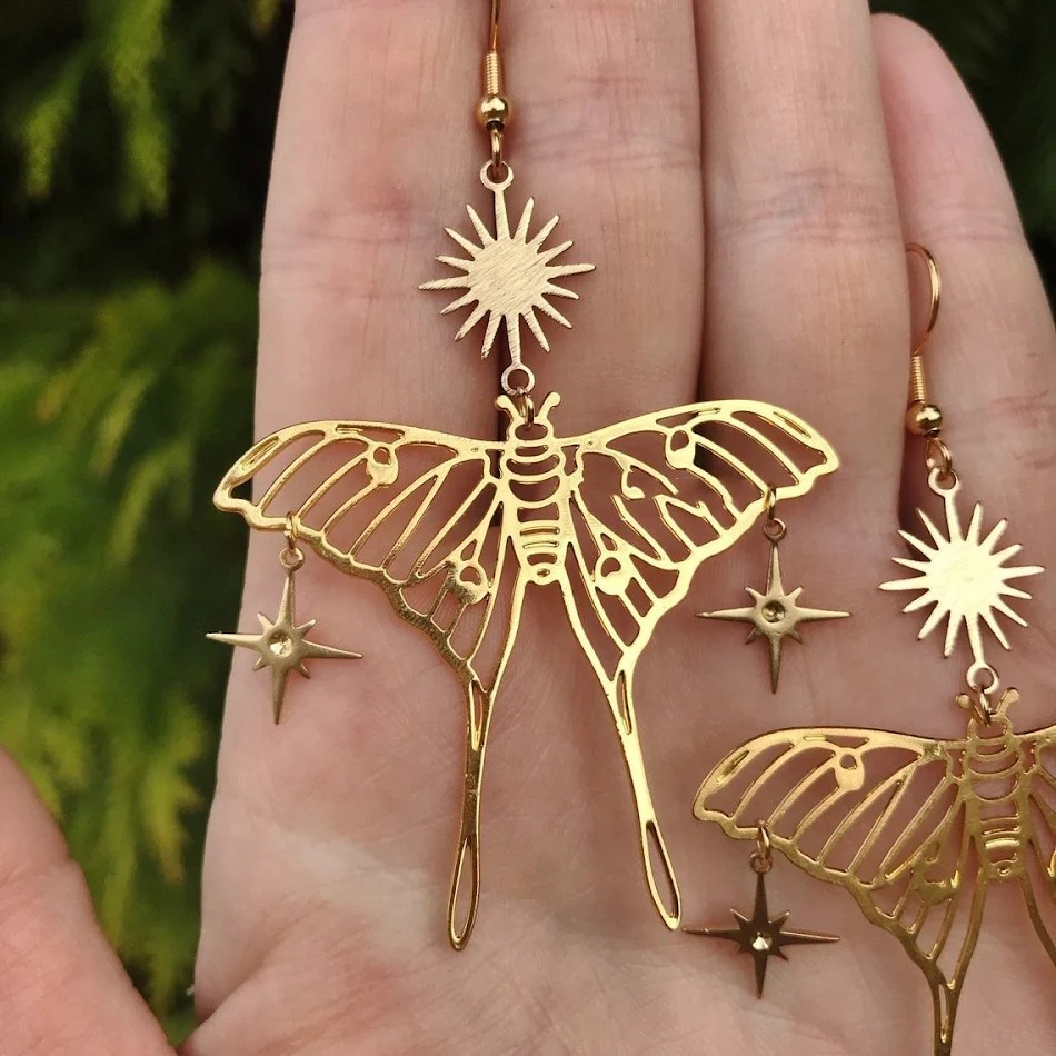 Boucles d'oreilles papillon creuses motif étoile et lune, un accessoire unique pour un style céleste et féminin.