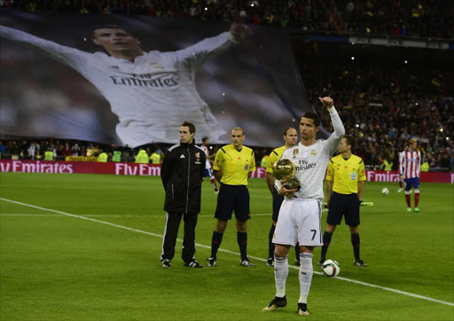 Real Madrid's Portuguese forward Cristiano Ronaldo poses with the 2014 FIFA Ballon d'Or award for player of the year prior to the Spanish Copa del Rey (King's Cup) round of 16 second leg football match Real Madrid CF vs Club Atletico de Madrid at the Santiago Bernabeu stadium in Madrid on January 15, 2015.