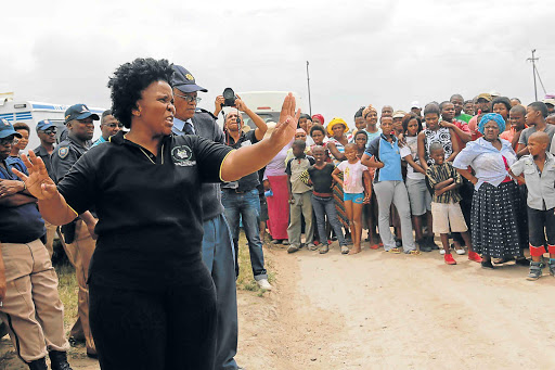 COOLING TEMPERS: Councillor Zameka Gajula addresses angry members of the community after some of them occupied RDP houses illegally in Unit P, Mdantsane, yesterday Picture: ALAN EASON