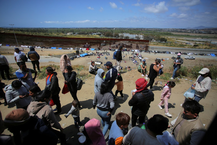 Migrants gather between the primary and secondary fences, as the US prepares to lift Covid-19 era restrictions, known as Title 42, that have blocked migrants at the US- Mexico border from seeking asylum since 2020, as seen from Tijuana, Mexico May 10 2023. Picture: REUTERS