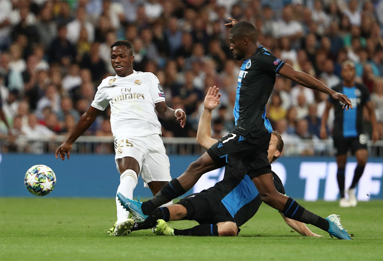 Real Madrid's Vinicius Junior in action with Club Brugge's Clinton Mata and Ruud Vormer