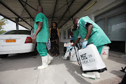 A health worker sprays a colleague with disinfectant during a training session for Congolese health workers to deal with Ebola virus in Kinshasa October 21, 2014. 