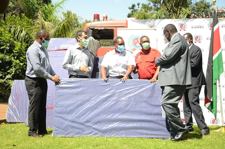 Nyoro receives a mattress on behalf of Kiambu Fire Rescue Team.