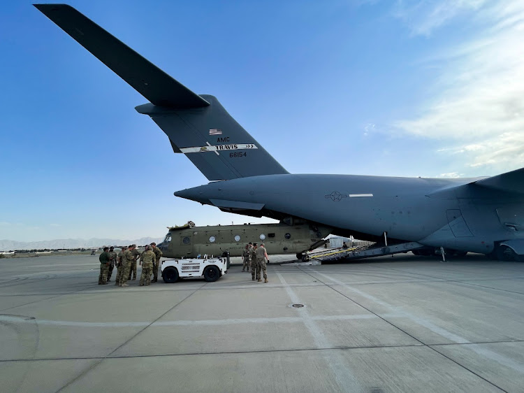 A CH-47 Chinook is loaded onto a US Air Force C-17 Globemaster III at Hamid Karzai International Airport in Kabul, Afghanistan. Picture: US CENTRAL COMMAND/REUTERS