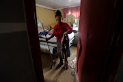 Bongiwe Zuma, 39, tries to mop up and remove water after rain flooded Peace Valley, Pietermaritzburg.