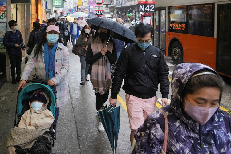 Pedestrians wearing face masks walk on the street following the outbreak of the coronavirus disease (Covid-19) in Hong Kong, China February 19, 2022.