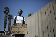 Braamfontein, Johannesburg. Mashau Glen Ndouvhada, POSES for a picture holding a cardboard box. He claims to have a B.S.C in Mining and Geology and is looking for employment .