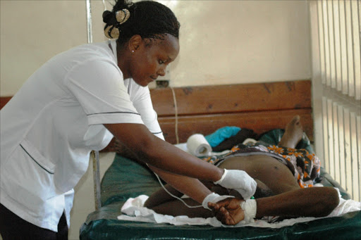 A nurse at Coast General Hospital casualty wing Marion Wakesho attends to cholera patient Jared Omambia from Likoni area at a secluded room in the hospital on Saturday. At least two people are suspected to have died of Cholera outbreak in Mombasa County. Photo Andrew Kasuku