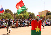 A man holds his national flag as people gather to show their support to the Junta leader Ibrahim Traore and demand the departure of the French ambassador at the Place de la Nation in Ouagadougou, Burkina Faso January 20, 2023.