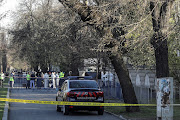 Police officers stand guard as crime scene investigators check the area where a car crashed into the gate of the Russian Embassy in Bucharest, Romania, April 6, 2022. 