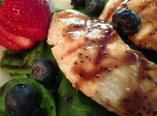 Grilled chicken with fresh strawberries and blueberries over a bed of spinach with Strawberry Balsamic glaze